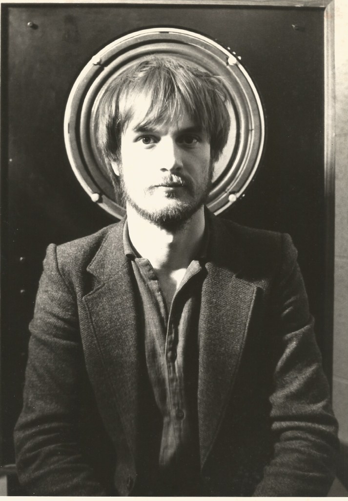 Richard Attree in 1982, aged 29, sat In front of a loud speaker.