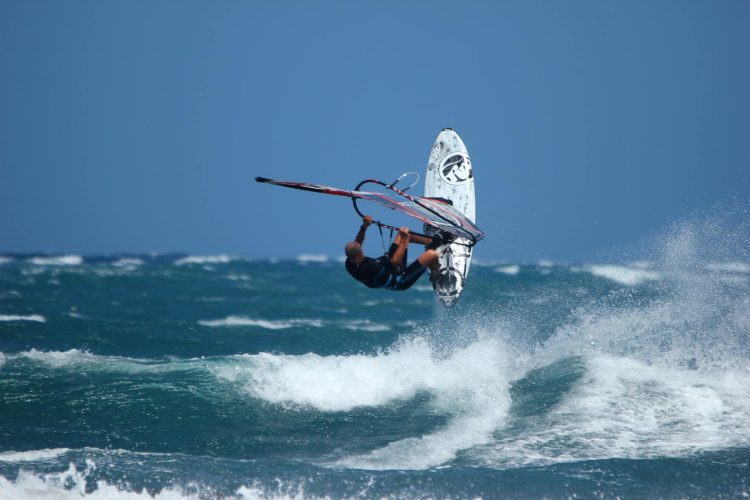 Richard Attree, windsurfing, jumping, in the air, enjoying a breezy day at his local beach in Tenerife