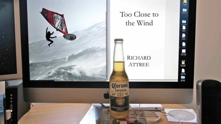 A bottle of beer in front of a screen displaying the manuscript of 'Too Close to the Wind'